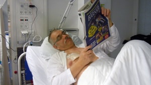 60-årige Christian Graver læser avis, før han tager sig en lur, mens han får dialys hele natten.