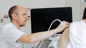 Overlæge Christian Borbjerg Laursen er ved at undersøge en patients lunger med ultralydsskanning. Pressefoto.
