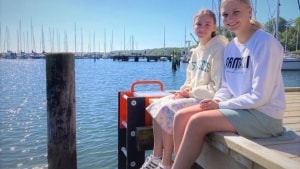 Milla Gam Isidor og Freja Balle Kjeldsen sidder ved den nye redningsstige i Brejning Lystbådehavn. Foto: Jørgen Flindt