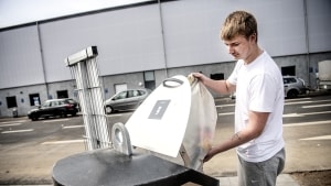 Den nye genbrugsplads får ros af blandt andre Jonas Herman, som her kaster en sæk tomme dåser i den underjordiske container. Foto: Michael Svenningsen