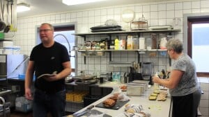 Bo Sørensen giver sprødstegt bacon ud af ovnen, mens Dorthe Sørensen sørger for at få smurt dagens bestilling af kyllingesandwich. Foto: Mette Louise Fasdal