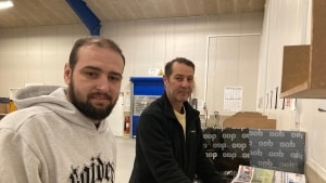 Avisbudene starter arbejdsdagen med at pakke aviser, pakker og breve og fordele det hele enten i bilen eller i taskerne på scooteren. Her er det Marius Cosma (tv) og Liviu-Simion Purcileanu. Begge er fra Rumænien. Foto: Hanne Bliksted