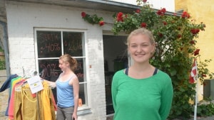 Anna Stub Thygesen foran sin sommershop i den tidligere Café Soze, mens en kunde lige tjekker ud, hvad hun har hængende af tøj udenfor. Foto: Palle Søby