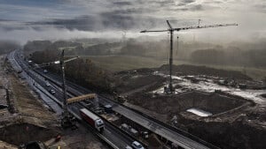 Morgentågen er ved at lette over byggepladsen ved Spedsbjergvej, hvor en ny bro skal bygges som erstatning for en ældre bro, der var for smal til at rumme det tredje spor. Foto: Michael Bager