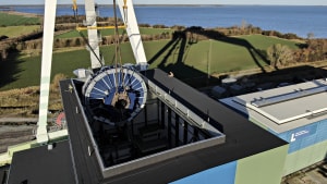 Verdens største testcenter til havvindmøller blev i 2020 etableret på Lindø. Her bliver verdens største drivmotor løftet på plads på testbænken i bygningen, der er blevet etableret til samme formål. Centeret lå uden for portalkranens rækkevidde, og af samme grund blev kransporet forlænget med 200 meter. Arkivfoto: Michael Bager