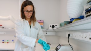 Charlotte Overgaard Wilhelmsen viser en labskala af et svampebatteri til lagring af grøn energi. Foto AAU Esbjerg