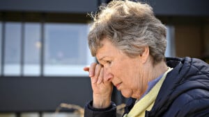 Karen Elise Mølgaard har svært ved at holde en tåre tilbage foran plejecentret i Bogense, hvor hun må undvære de daglige besøg hos ægtefællen. Foto: Michael Bager
