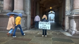 Caroline Mahler Lundsteen viser her skiltet, som hun brugte hver fredag indtil sin 9. klasses eksamen i et forsøg på at råbe politikerne op og forlange mere handling på klimaområdet. Foto: Emilie Aagaard