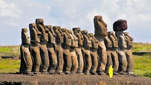 De 15 statuer her på stranden ved Tongariki blev restaureret og genrejst i 1992 med hjælp fra en japansk kran. Den største af statuerne vejer 86 ton er 10 meter høj. Den påsatte hat på den næstsidste figur vejer cirka 11,5 ton. Den gule mand i forgrunden illustrerer størrelsesforholdet til en normal voksen person. Foto: Jøgen Leon Knudsen