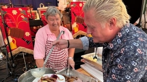 Lisbeth Lautrup Knudsen udleverer mad, mens Torben Pop skænker op til sig selv. Foto: Hans Petersen